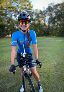 woman on a bike wearing sunglasses smiling