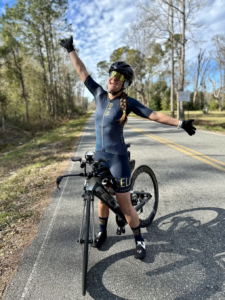 A female triathlete who is very happy to be riding her bike.