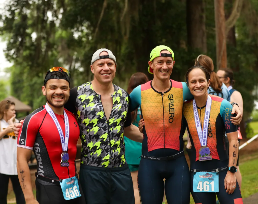 four triathletes with their medals after a triathlon