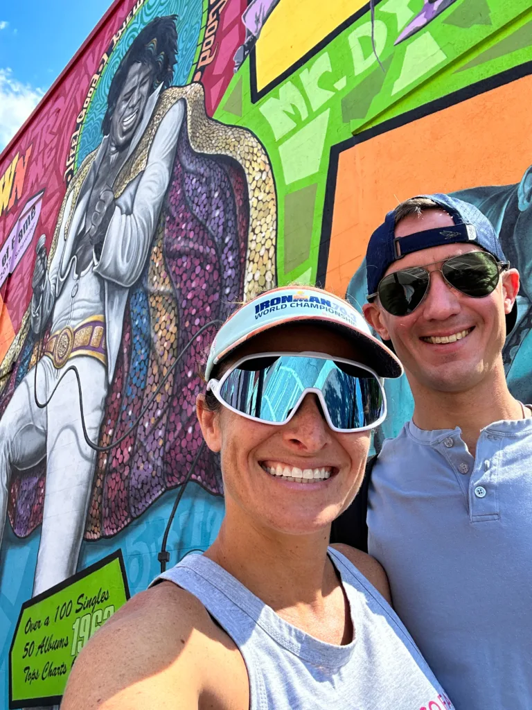two people in front of a mural