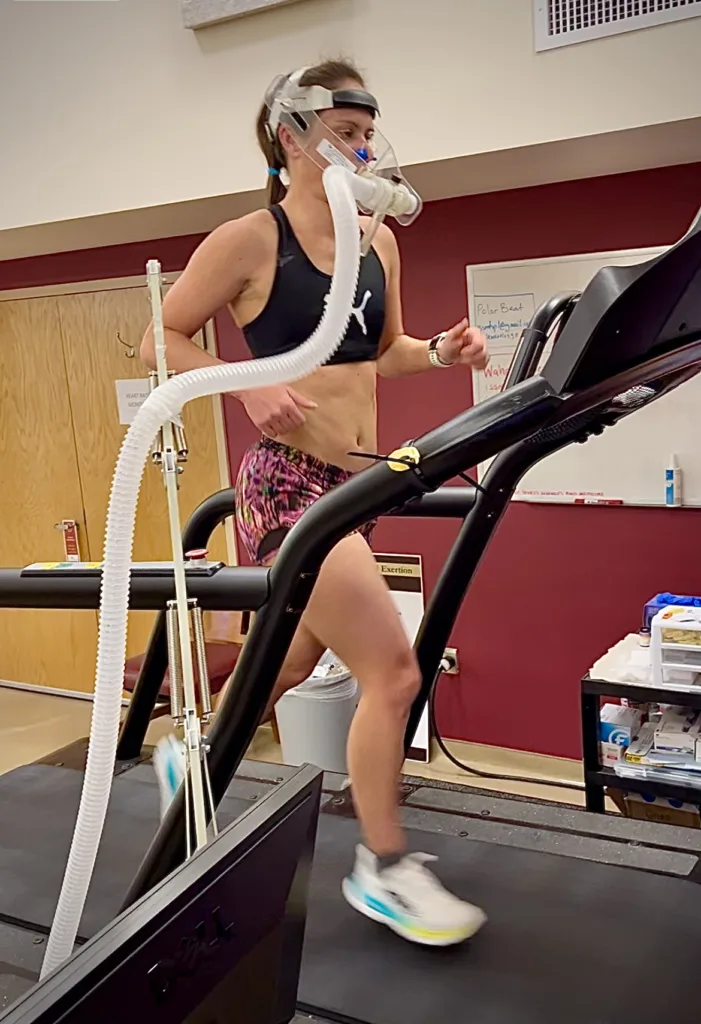 a female athlete runs on a treadmill while doing VO2 max testing.