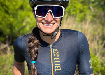 A female triathlete smiling while wearing cool sunglasses