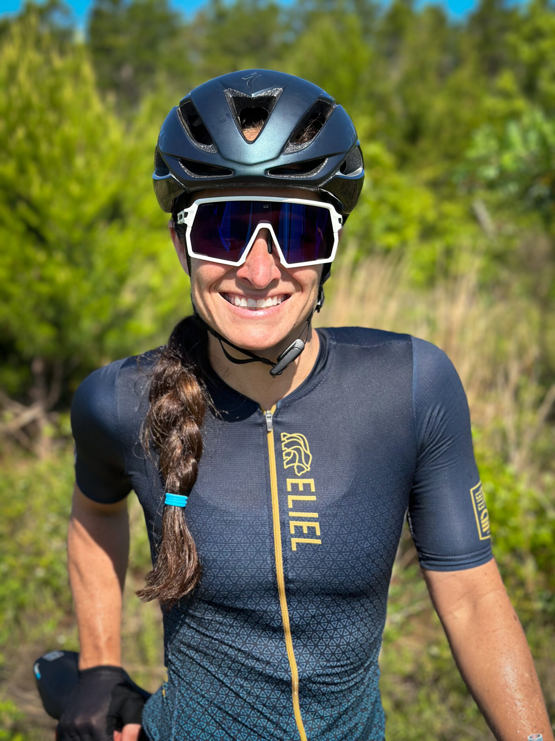 A female triathlete smiling while wearing cool sunglasses